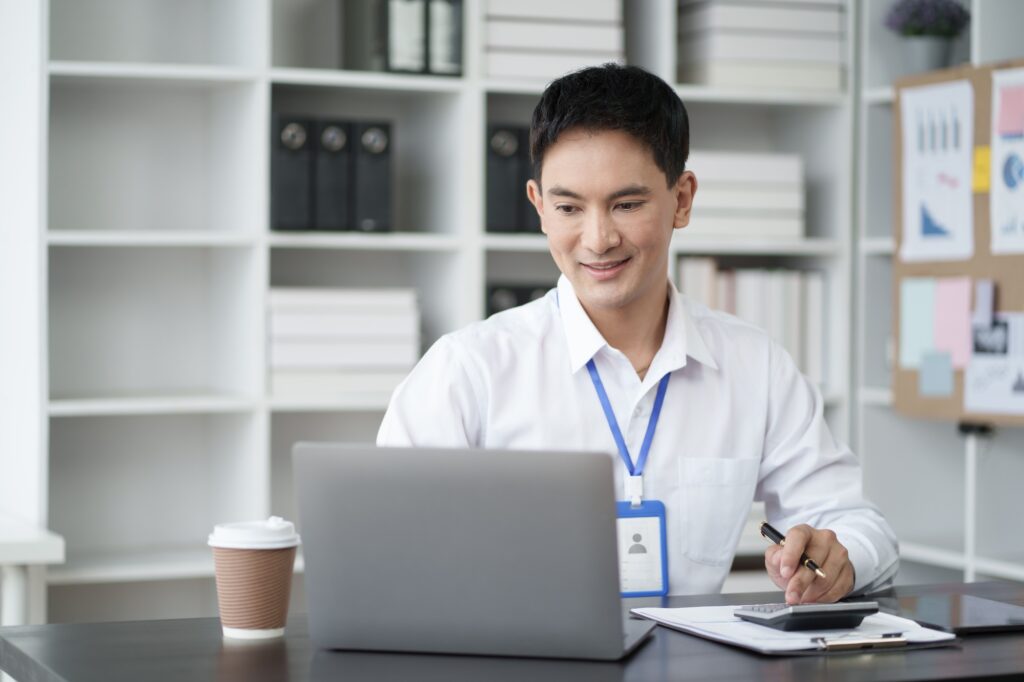 Young Asian businessman use digital calculator for tax, salary and personal expenses.